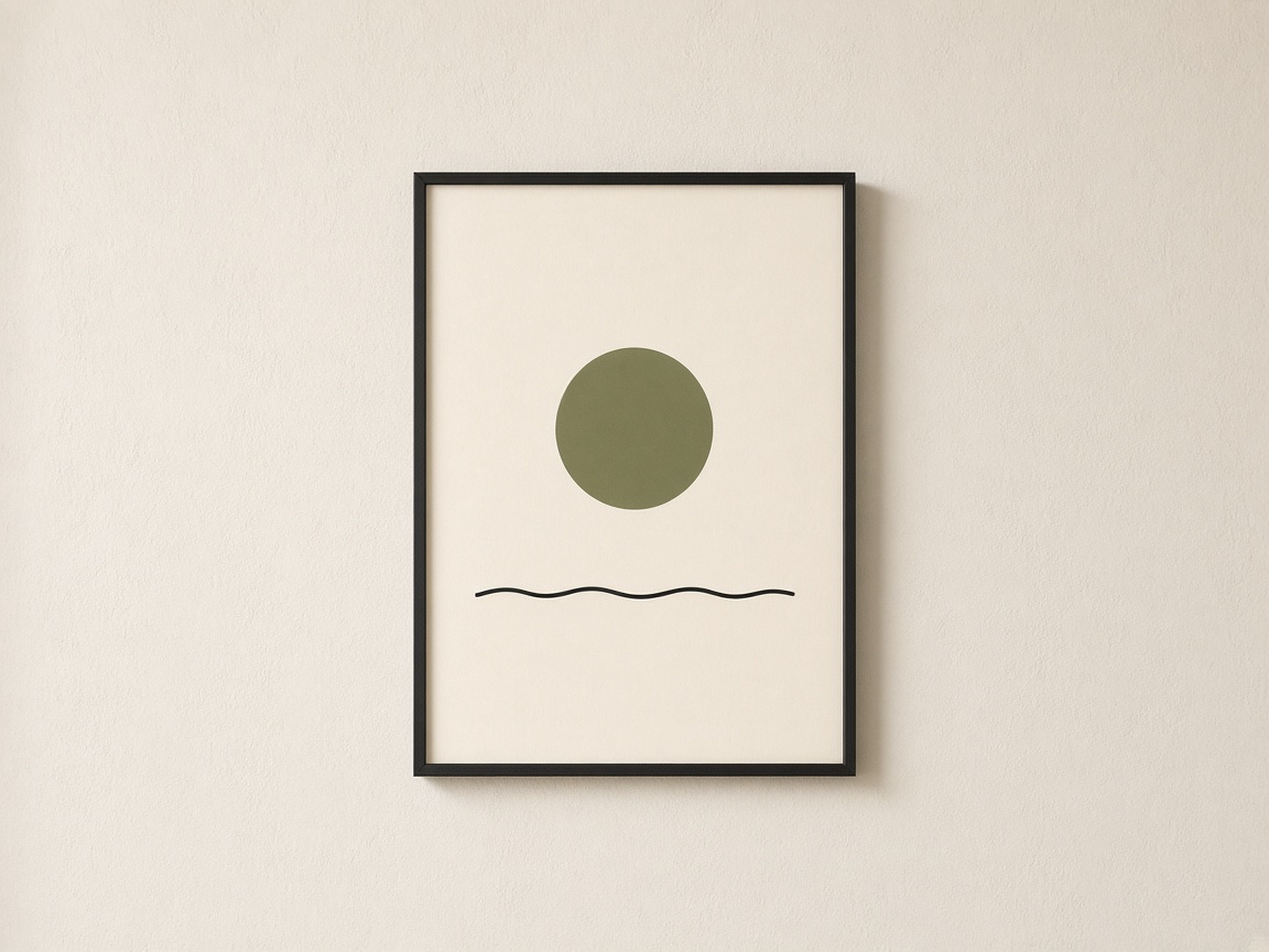 Black framed print of an olive sun over a thin black line, hanging on a cream wall